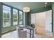Bright home office with green walls, ample natural light, and a modern desk and seating arrangement at 5010 Ohm Ln, Charlotte, NC 28270