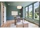 Stylish home office featuring a desk, plush seating, three windows, and light hardwood floors at 5010 Ohm Ln, Charlotte, NC 28270