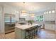 Bright, modern kitchen featuring an island with bar stools, custom cabinets and stainless steel appliances at 5010 Ohm Ln, Charlotte, NC 28270