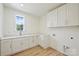 Bright laundry room boasts ample counter space, storage cabinets, and modern fixtures at 5010 Ohm Ln, Charlotte, NC 28270
