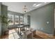 Bright home office with three windows, modern light fixture, hardwood floors, and neutral color palette at 5010 Ohm Ln, Charlotte, NC 28270