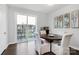 Bright dining area with modern lighting, light walls, wood table, four chairs, and sliding glass doors to balcony at 510 Music Hall Way, Charlotte, NC 28203