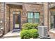Close-up of a townhome's front entrance, featuring a brick facade and manicured bushes at 510 Music Hall Way, Charlotte, NC 28203