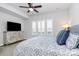 Bright bedroom features a ceiling fan, television, large window with white shutters, and plush carpet at 510 Music Hall Way, Charlotte, NC 28203