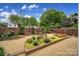 Backyard featuring a gravel pathway, manicured garden area with shrubs and colorful flowers at 5404 Dunedin Ln, Charlotte, NC 28270