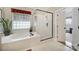 Modern bathroom with a glass enclosed shower, soaking tub and large window providing natural light at 5404 Dunedin Ln, Charlotte, NC 28270