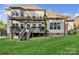 Spacious backyard with a deck, stairs, lush lawn, and mature trees creating a relaxing outdoor space at 551 Hemmings Nw Pl, Concord, NC 28027