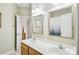 Well-lit bathroom featuring double sinks with bright mirrors and modern fixtures, alongside light wood cabinetry at 551 Hemmings Nw Pl, Concord, NC 28027
