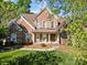 Charming two-story brick home featuring a covered front porch and manicured lawn at 551 Hemmings Nw Pl, Concord, NC 28027