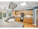 Well-lit kitchen featuring wooden cabinets, gray countertops, and modern appliances at 551 Hemmings Nw Pl, Concord, NC 28027