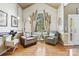 Cozy living room featuring comfortable seating, a large arched window, and stylish decor for relaxation at 551 Hemmings Nw Pl, Concord, NC 28027