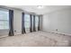 Bedroom with three windows, neutral walls, and carpet flooring at 5628 Selkirkshire Rd, Charlotte, NC 28278