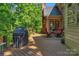 Cozy back porch with outdoor seating and a grill, surrounded by mature trees at 6017 Summerston Pl, Charlotte, NC 28277
