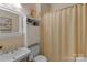 Cozy bathroom with neutral walls and a tub with a curtain and decorative storage cabinet at 6017 Summerston Pl, Charlotte, NC 28277