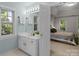 Bright and airy bathroom featuring dual sinks, a large mirror, and an ensuite bedroom with neutral décor at 6017 Summerston Pl, Charlotte, NC 28277