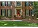 Charming brick facade with a welcoming red front door and manicured landscaping at 6017 Summerston Pl, Charlotte, NC 28277