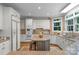 Bright kitchen features white cabinets, stainless steel appliances, granite countertops, and a center island with bar stool seating at 6017 Summerston Pl, Charlotte, NC 28277