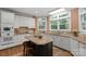 Bright kitchen features white cabinets, stainless steel appliances, granite countertops, a center island and natural lighting at 6017 Summerston Pl, Charlotte, NC 28277