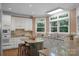 Bright kitchen features white cabinets, stainless steel appliances, granite countertops, and a center island with bar stool seating at 6017 Summerston Pl, Charlotte, NC 28277