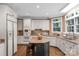 Bright kitchen features white cabinets, stainless steel appliances, granite countertops, and a center island with bar stool seating at 6017 Summerston Pl, Charlotte, NC 28277