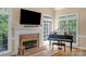 Living room with fireplace, piano, and an abundance of natural light from many windows at 6017 Summerston Pl, Charlotte, NC 28277