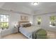 Bright main bedroom with a tray ceiling and ample natural light, a cozy sitting area, and neutral decor at 6017 Summerston Pl, Charlotte, NC 28277