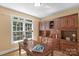 Home office with a large desk and a full wall of built-in wooden cabinets and shelving at 6017 Summerston Pl, Charlotte, NC 28277