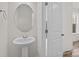 Small bathroom featuring a pedestal sink with a round mirror and a white paneled door at 655 District Ct, Fort Mill, SC 29708