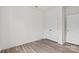 Bright, minimalist bedroom featuring wood-look floors, white walls, a closet, and a paneled door at 655 District Ct, Fort Mill, SC 29708