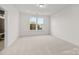 Bright bedroom with a large window providing natural light and carpet flooring at 655 District Ct, Fort Mill, SC 29708