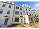 Eye-level exterior shows the front of a three-story modern white townhome with black window trim and a covered porch at 655 District Ct, Fort Mill, SC 29708