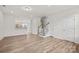 Large, bright living room shows wood-look flooring, white walls, a staircase, and a kitchen area in the background at 655 District Ct, Fort Mill, SC 29708