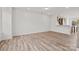 Spacious living room with wood-look flooring and white walls, leading to a kitchen and dining area at 655 District Ct, Fort Mill, SC 29708