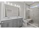 Modern Primary bathroom with dual sinks, gray cabinetry, large mirror and tiled shower at 657 District Ct, Fort Mill, SC 29708