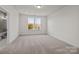 Bright bedroom with neutral carpet, double windows, and an ensuite bath with tiled shower at 657 District Ct, Fort Mill, SC 29708