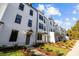 Modern townhomes with white exteriors, green lawns and tasteful landscaping on a bright day at 657 District Ct, Fort Mill, SC 29708
