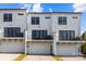 Modern townhouse with white facade, garages, and balconies under a beautiful blue sky at 657 District Ct, Fort Mill, SC 29708