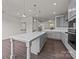 Open concept kitchen with a spacious island, gray cabinets, stainless steel appliances, and wood flooring throughout at 657 District Ct, Fort Mill, SC 29708