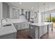 Modern kitchen featuring gray cabinets, stainless steel appliances, an island, and wood flooring at 657 District Ct, Fort Mill, SC 29708