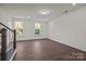 Bright living room with hardwood floors, staircase, large windows showcasing natural light at 657 District Ct, Fort Mill, SC 29708