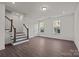 Well-lit living room with hardwood floors, a staircase, and bright windows at 657 District Ct, Fort Mill, SC 29708