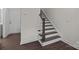 Elegant staircase featuring hardwood floors, white risers, and a classic newel post at 657 District Ct, Fort Mill, SC 29708