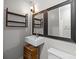 Updated bathroom includes a sink, decorative mirror, open shelving, and a toilet at 700 Oakland Ave, Charlotte, NC 28204