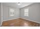 Bright bedroom features hardwood floors, two windows, and neutral paint at 700 Oakland Ave, Charlotte, NC 28204