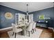 Dining room featuring blue walls, wood floors, a modern light fixture, and large windows overlooking the yard at 700 Oakland Ave, Charlotte, NC 28204