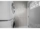 Bright laundry room with stackable washer and dryer and convenient wall hooks for storage at 700 Oakland Ave, Charlotte, NC 28204