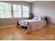 Light-filled bedroom with bamboo floors, large windows, and a comfortable bed with decorative pillows and bedspread at 788 N Main St, Mount Pleasant, NC 28124