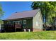 Exterior view of a green house with a metal roof, back deck, and lush lawn, perfect for outdoor living at 788 N Main St, Mount Pleasant, NC 28124
