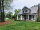 Charming home showcasing a landscaped yard and inviting front porch with classic columns and cozy rocking chairs at 788 N Main St, Mount Pleasant, NC 28124