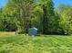 Backyard featuring a storage shed surrounded by a lush green lawn and mature trees, offering ample space at 788 N Main St, Mount Pleasant, NC 28124